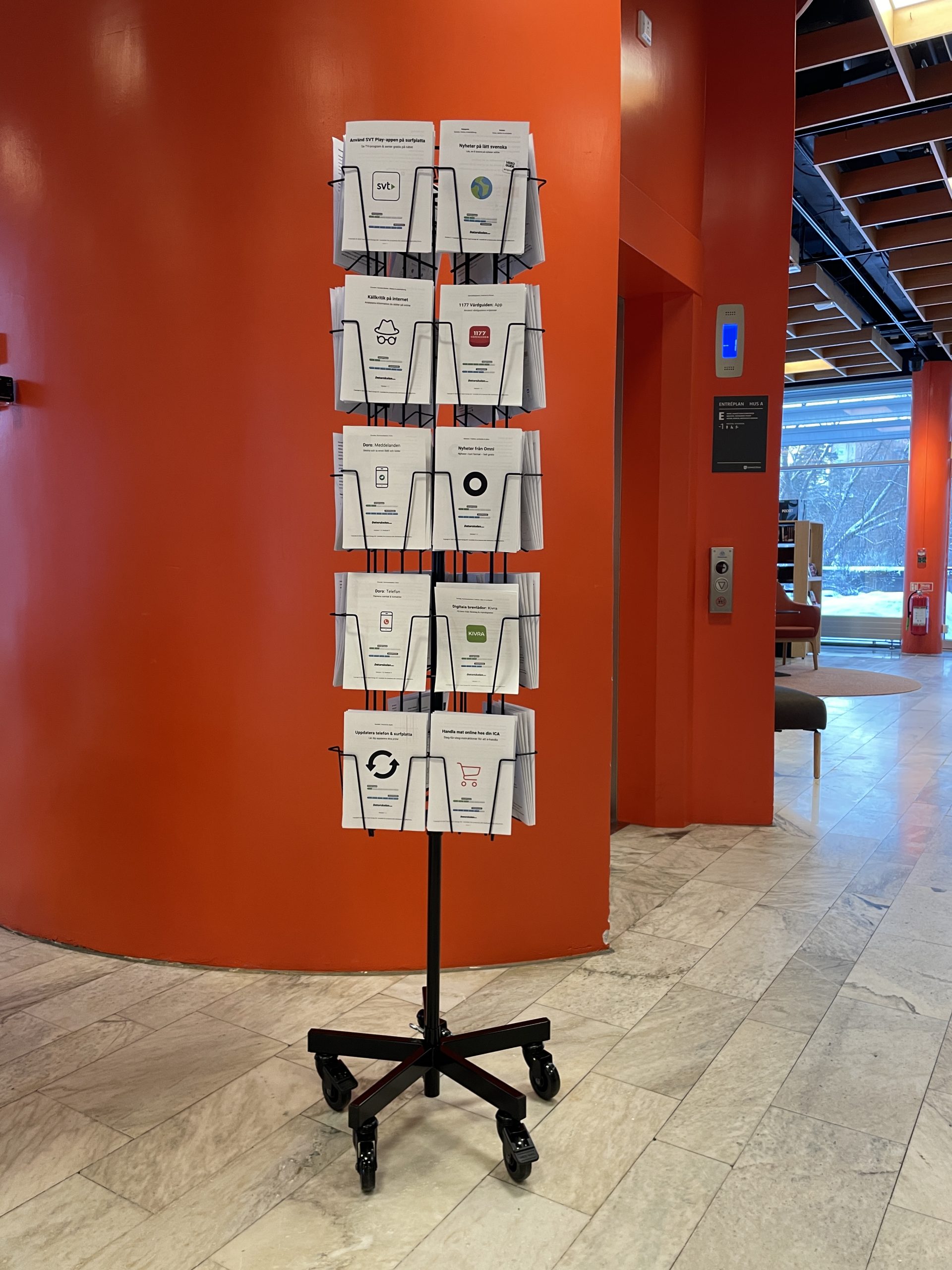 Ett ställ med DigiGuider står på golvet på Lidingö Stadsbibliotek